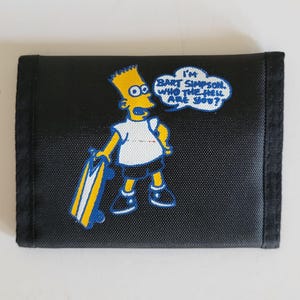 May include: Black tri-fold wallet featuring Bart Simpson holding a skateboard. The cartoon character is yellow with blue and white accents. A speech bubble says, "I'm Bart Simpson, who the hell are you?"