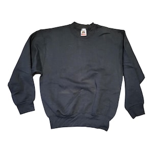 Peut inclure: Un sweat-shirt noir à col rond et manches longues. Le sweat-shirt a un ourlet et des poignets côtelés. L'étiquette de la marque est visible au niveau de l'encolure. Le vêtement est fait d'une matière douce et confortable.