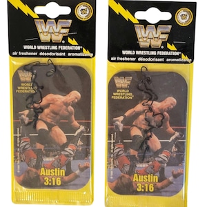 May include: Two vintage WWF (World Wrestling Federation) air fresheners. Each yellow and black package features a wrestler image and the text "Austin 3:16". The top of each package has the WWF logo and the words "air freshener désodorisant aromatizante".