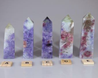 May include: Five purple, pink, and green crystal points labeled A through E. The points are arranged in a row on a white surface.