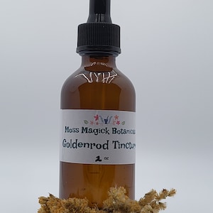 May include: A brown glass bottle with a black dropper top. The bottle is labeled "Moss Magick Botanicals Goldenrod Tincture 1 oz."