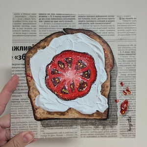 Puede incluir: Una obra de arte pintada de una rebanada de pan tostado con una gruesa capa de crema blanca y una rodaja de tomate rojo encima, colocada sobre un periódico.