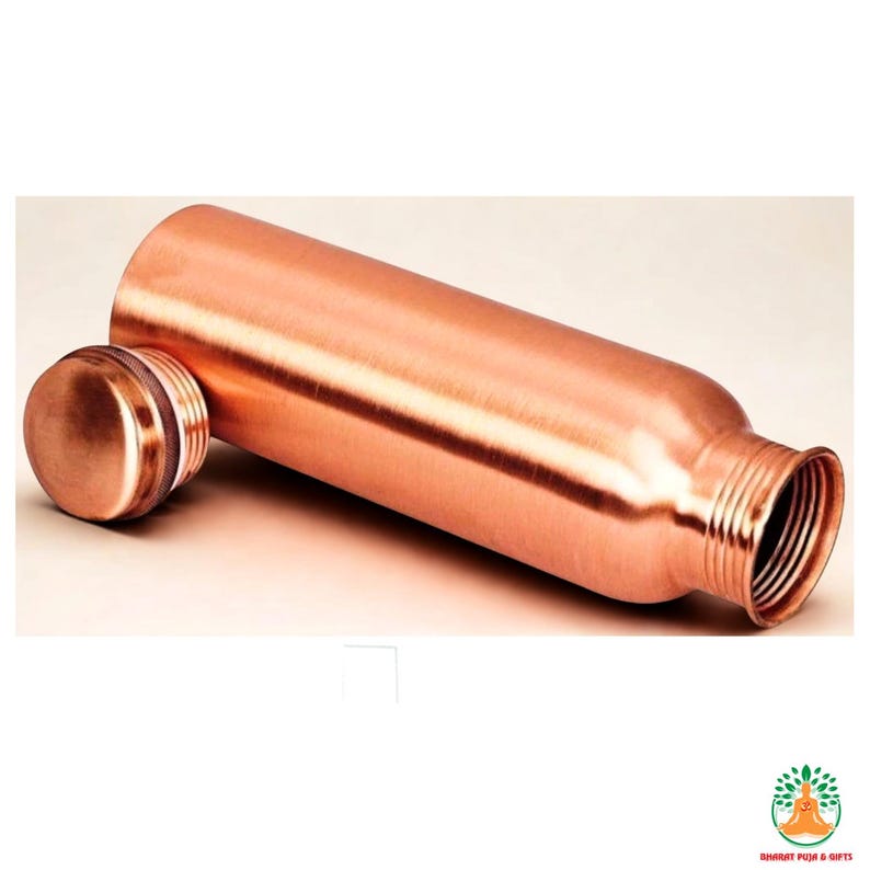 May include: A copper-colored water bottle with a matching screw-on lid. The bottle is cylindrical with a slightly wider base and a threaded opening. The lid is round and has a textured edge. The bottle is lying on its side.