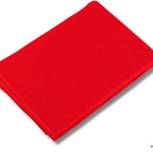 Pode incluir: Uma pilha de tecido vermelho dobrado, provavelmente um pano ou têxtil. O tecido é de uma cor vermelha sólida e vibrante e parece ser feito de um material liso. As bordas são cuidadosamente dobradas, sugerindo um produto acabado.