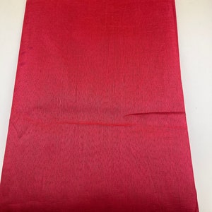Könnte beinhalten: Ein einfarbiges rotes Blatt Seidenpapier. Das Papier hat eine leicht strukturierte Oberfläche.