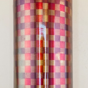 May include: A stainless steel water bottle with a checkered pattern in shades of red, gold, and purple. The bottle has a silver lid and a light blue gasket. The design is reminiscent of a plaid pattern.
