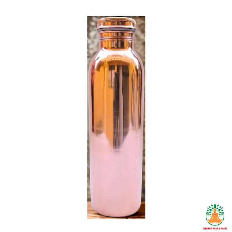May include: A copper water bottle with a shiny, metallic finish. The top and cap are a darker copper color, while the bottom half is painted a soft pink. The bottle has a sleek, cylindrical shape.