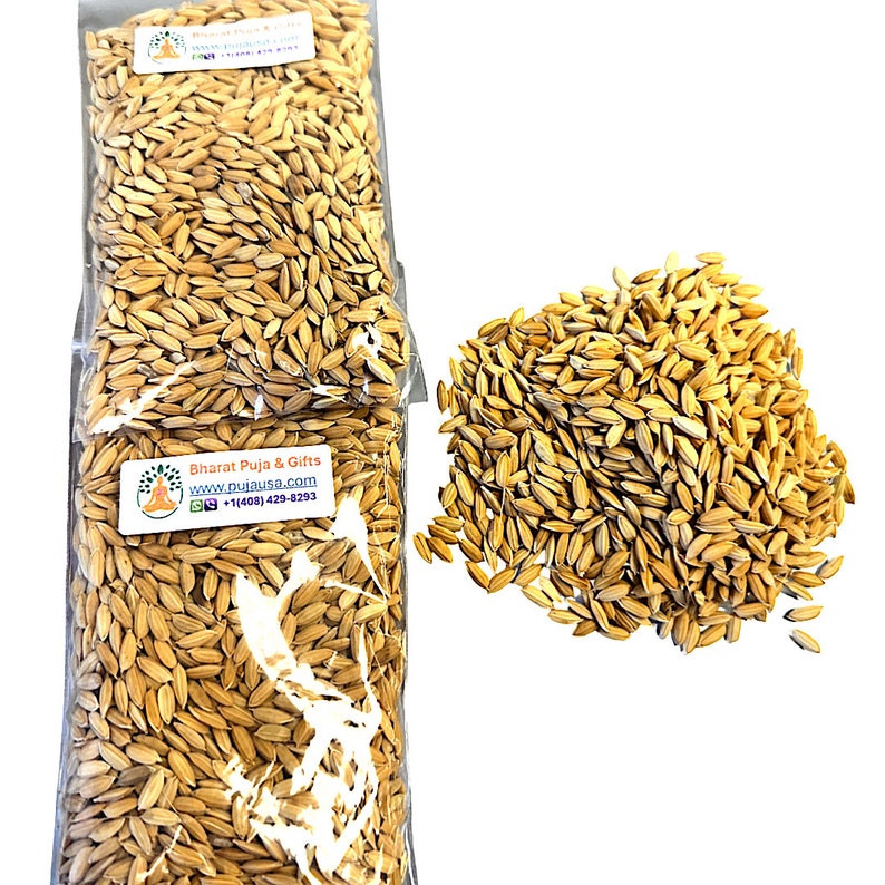 May include: Two clear plastic bags filled with golden-colored rice grains, alongside a loose pile of the same grains. The bags have labels with text and a logo. The grains are a light tan color, and the image is well-lit.