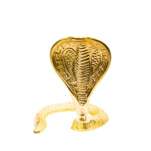Pode incluir: Estátua dourada de uma cobra com detalhes intrincados. A cobra está em uma pose de ataque, com o capuz aberto e o corpo enrolado. A estátua é feita de um material dourado brilhante e reflexivo, sobre um fundo branco.
