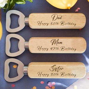 May include: Three wooden bottle openers with metal bottle opener tops. Each opener has a personalised message: "Dad Happy 50th Birthday", "Mom Happy 47th Birthday", and "Sister Happy 30th Birthday".