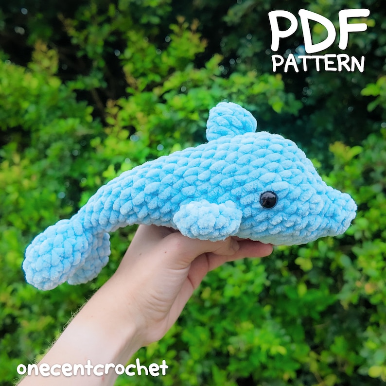 Puede incluir: Un juguete de amigurumi de delf&iacute;n azul tejido a crochet con ojos negros. PATR&Oacute;N PDF.
