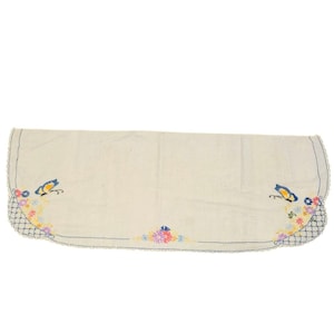 May include: Cream-colored embroidered table runner with a scalloped edge. Features blue butterflies and colorful floral embroidery at each end. The embroidery includes pink, yellow, and purple flowers.