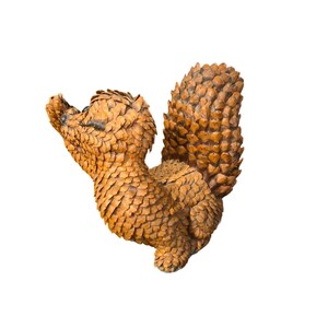 May include: A handcrafted squirrel figurine made from small, overlapping pieces of wood. The squirrel is in a playful pose, with its head tilted back and its tail arched. The wood has a warm, natural brown color.
