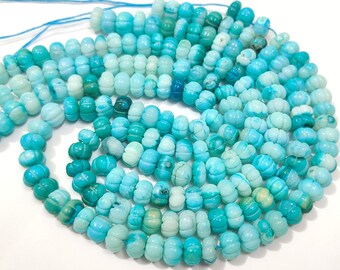 May include: A strand of blue and white gemstone beads. The beads are round and have a slightly irregular shape. They are strung on a thin thread.