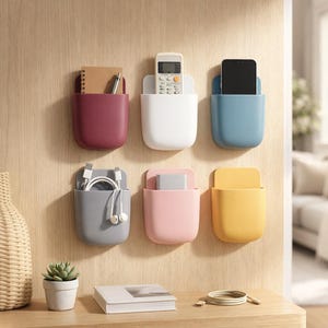 Peut inclure: Six organisateurs de rangement muraux en bordeaux, blanc, bleu, gris, rose et jaune. Chaque support rectangulaire présente un fond arrondi et contient des objets tels qu'un carnet, un stylo, une télécommande, un smartphone, des câbles et un adaptateur.