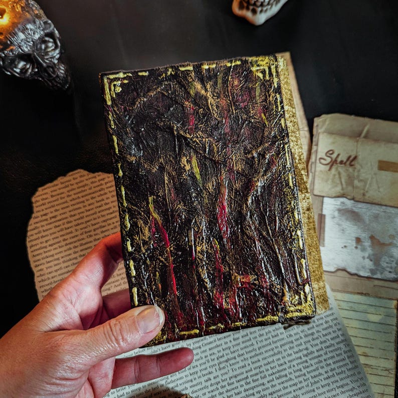 Occult spellbook with sculpted skull face cover, horror-style design on vintage papers