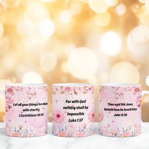 Op de afbeelding: Drie witte keramische mokken met roze bloemenmotieven en inspirerende citaten. De mokken bevatten de volgende citaten: "Laat al uw daden met liefde geschieden 1 Korinti&euml;rs 16:14", "Want bij God is niets onmogelijk Lukas 1:37", en "Toen zeiden de Joden: Zie, hoezeer hij hem liefhad Johannes 11:36".