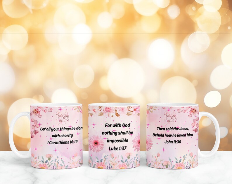 Op de afbeelding: Drie witte keramische mokken met roze bloemenmotieven en inspirerende citaten. De mokken bevatten de volgende citaten: "Laat al uw daden met liefde geschieden 1 Korinti&euml;rs 16:14", "Want bij God is niets onmogelijk Lukas 1:37", en "Toen zeiden de Joden: Zie, hoezeer hij hem liefhad Johannes 11:36".