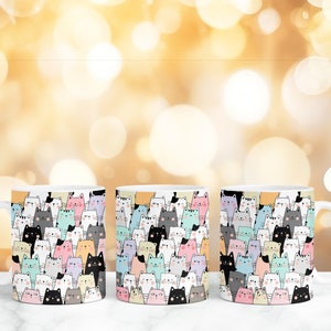 May include: Three white ceramic mugs with a colorful pattern of cartoon cats. The cats are in various colors, including pink, blue, yellow, and gray.