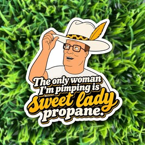 May include: A die-cut sticker featuring a cartoon character wearing a white cowboy hat with a yellow feather and leopard print band, glasses, and a white shirt. The text reads: The only woman I'm pimping is sweet lady propane.