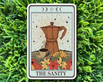 May include: A tarot card with a blue background and a brown coffee pot, a cup of coffee, and cookies. The card says "THE SANITY" at the bottom.