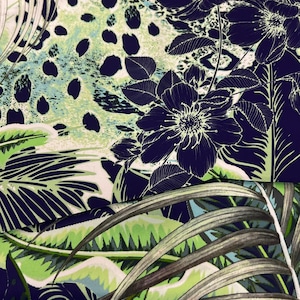 Op de afbeelding: Een stof met een donkerblauwe achtergrond met een bloemen- en bladerpatroon in wit en groen. Het ontwerp omvat grote, gestileerde bloemen en tropisch gebladerte, met een luipaardprint-achtig patroon op de achtergrond.