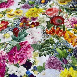 May include: A white fabric with a floral print featuring a variety of flowers in shades of pink, red, yellow, blue, and white. The flowers are arranged in a random pattern and appear to be realistic.