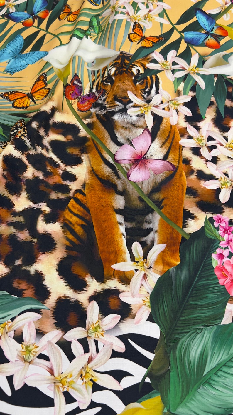 K&ouml;nnte beinhalten: Ein Tiger mit orangefarbenen und schwarzen Streifen sitzt in einer Dschungelkulisse mit wei&szlig;en Bl&uuml;ten, gr&uuml;nen Bl&auml;ttern und Schmetterlingen. Der Tiger ist von einem Leopardenmuster umgeben.