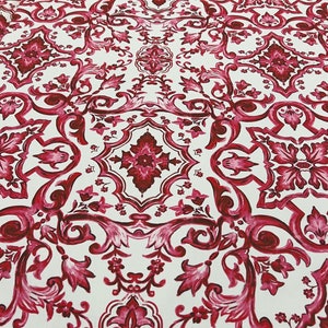 May include: White fabric with a repeating pattern of red and pink floral designs. The pattern resembles a traditional tile design.