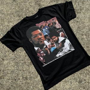 May include: Black t-shirt featuring a graphic from the movie "Higher Learning." The design includes images of several actors and the text "Higher Learning." The shirt also has the text "THIS DESIGN WAS CREATED BY SOUTHSIDE DESIGN DISTRICT FOR KICKART STUDIO."
