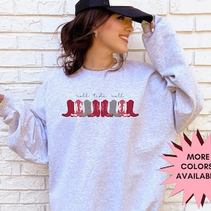 May include: Gray sweatshirt with the text "roll tide roll" and a graphic of red and gray cowboy boots.