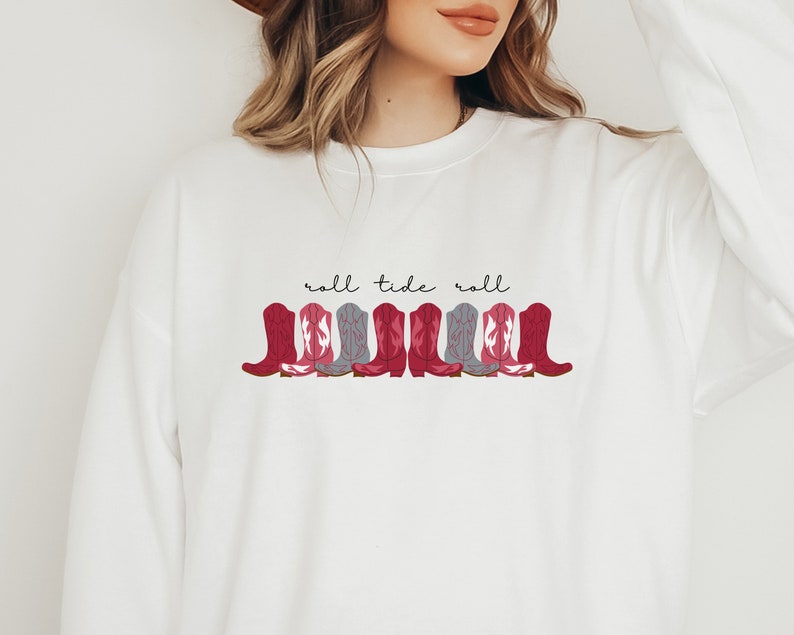 May include: White sweatshirt with a red and gray cowboy boot design and the text "roll tide roll" in black.
