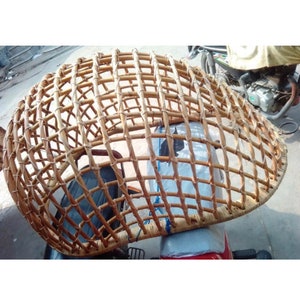 May include: A woven wicker dome-shaped structure, possibly a protective cover for a motorcycle.
