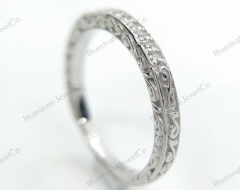 May include: A silver ring with an engraved floral pattern and small, clear stones set along the top. The ring is on a white background, with the words "Illuminate JewelCo" in the background.