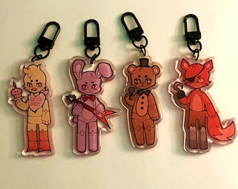 May include: Four acrylic keychains featuring cartoon characters from a video game. The characters include a yellow chicken holding a cupcake, a pink bunny with a guitar, a brown bear with a microphone, and a red fox with an eye patch.
