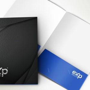 May include: A black presentation folder with a textured finish and the "eXp REALTY" logo in silver. The folder is partially open, revealing a white interior and a blue pocket with the same logo.
