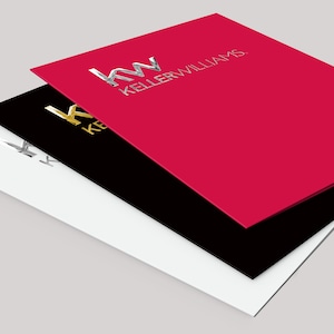 May include: Three folders stacked on top of each other. The top folder is red with the text "KW KELLERWILLIAMS" in white. The middle folder is black with the text "KW KELLERWILLIAMS" in gold. The bottom folder is white with the text "KW KELLERWILLIAMS" in silver.