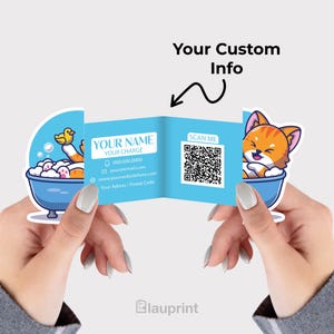 May include: A light blue business card with a cartoon cat and duck in a bathtub design. The card has a QR code and space for custom information. The card is held between two hands.