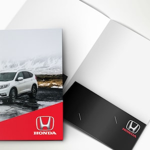 May include: A white Honda SUV parked on a snowy road with a red and black background featuring the Honda logo and the word "HONDA".
