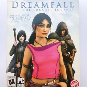 May include: Dreamfall: The Longest Journey PC CD-ROM software box art. The cover features a woman in a pink top, with two other characters. The game is rated Mature 17+.