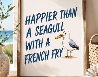 May include: A framed print with the text "Happier Than a Seagull With a French Fry" in blue script. A cartoon seagull with a french fry in its beak is to the right. The print is in a wooden frame.