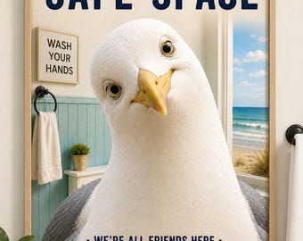 May include: Framed wall art with a large seagull illustration. The text at the top reads "THIS IS A SAFE SPACE" in navy blue. Below the seagull, the text reads "WE'RE ALL FRIENDS HERE." A small sign says "WASH YOUR HANDS."