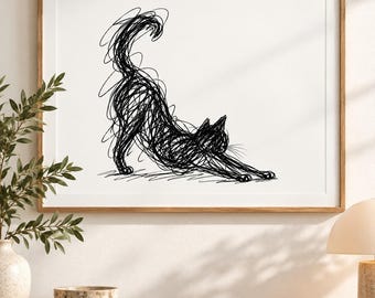 May include: A framed wall art print featuring a black ink scribble drawing of a cat in a stretching pose. The cat is depicted with chaotic, overlapping lines on a plain white background, enclosed within a simple light-colored wooden frame.