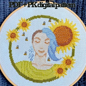 May include: Cross-stitch embroidery in a wooden hoop. The design features a woman's face with blue hair, surrounded by sunflowers and bees. The text "PDF + PK digital pattern" is at the top.