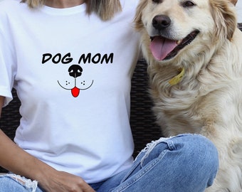 Könnte beinhalten: Ein weißes T-Shirt mit dem Text "DOG MOM" und einem Cartoon-Hundegesicht mit roter Zunge. Eine Person trägt das Shirt und streichelt einen Golden Retriever.
