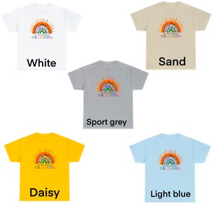 Peut inclure: Cinq t-shirts de diff&eacute;rentes couleurs, chacune arborant un arc-en-ciel avec le texte "We Are Hungry For Learning". Les couleurs sont le blanc, le sable, le gris sport, le jaune daisy et le bleu clair.