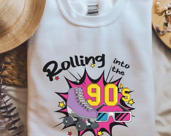 May include: White sweatshirt with a pink, yellow, and black graphic of a roller skate and the text "Rolling into the 90's".