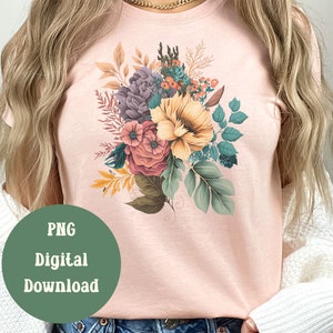 May include: A pink t-shirt featuring a floral design with a bouquet of flowers in shades of purple, yellow, pink, and green.