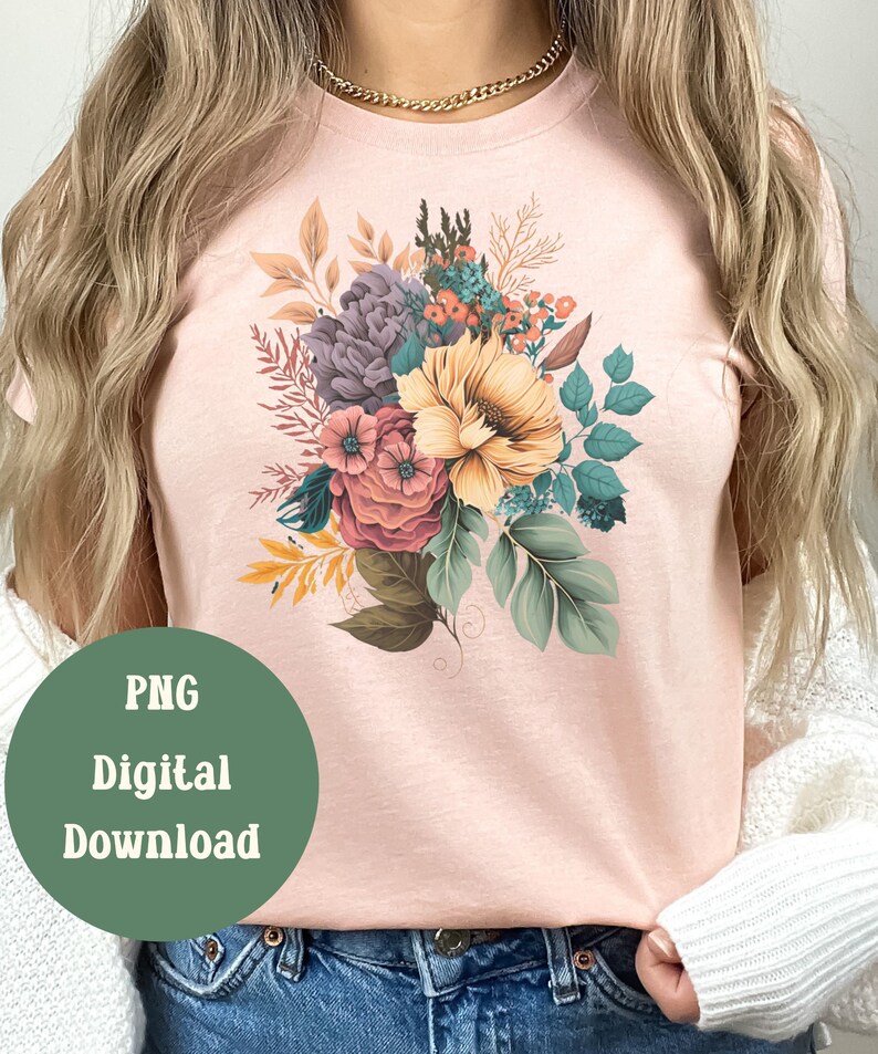 May include: A pink t-shirt featuring a floral design with a bouquet of flowers in shades of purple, yellow, pink, and green.