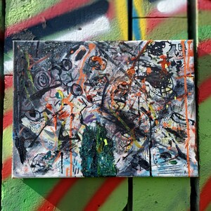 May include: Abstract painting on canvas with black, white, orange, green, and blue paint splatters and brushstrokes.